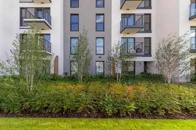 an apartment building with a garden in front of it at Apartments Cracow Rakowicka by Noclegi Renters in Kraków