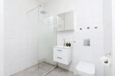 a white bathroom with a toilet and a sink at Apartments Cracow Rakowicka by Noclegi Renters in Kraków
