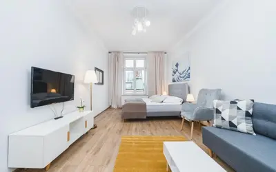 a living room with a blue couch and a tv at Beautiful Apartment on Main Square / Old Town / City Center in Kraków