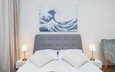 a white bed with two blue pillows on it at Beautiful Apartment on Main Square / Old Town / City Center in Kraków