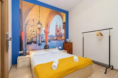 a bedroom with a large bed with a painting on the wall at Deluxe Apartments Kraków Brzozowa by Noclegi Renters in Kraków