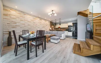 a dining room and living room with a table and chairs at Deluxe Apartments Kraków Brzozowa by Noclegi Renters in Kraków