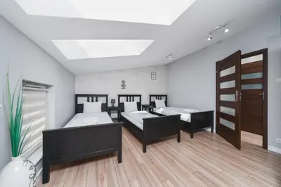 a room with three beds and a door in it at Deluxe Apartments Kraków Brzozowa by Noclegi Renters in Kraków