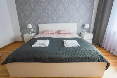 a bedroom with a large bed with two night stands at Apartament Pod Winogronami in Kraków