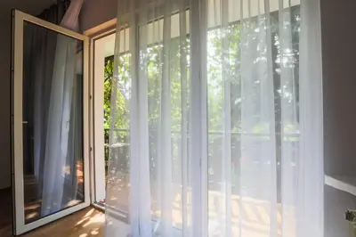a room with a window with white curtains at Apartament Pod Winogronami in Kraków