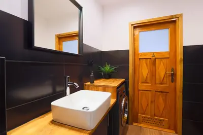 a bathroom with a white sink and a mirror at Apartament Pod Winogronami in Kraków