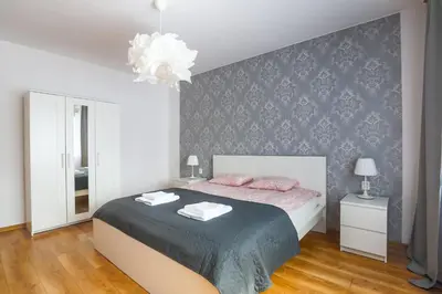 a bedroom with a bed with pink pillows on it at Apartament Pod Winogronami in Kraków