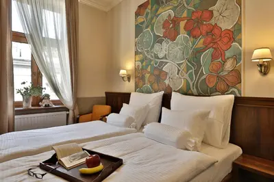 a hotel room with a bed with a tray of fruit on it at Amber Boutique Hotels - Amber Design in Kraków