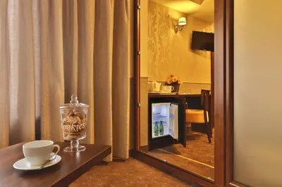 a hotel room with a bed and a desk and a mirror at Amber Boutique Hotels - Amber Design in Kraków