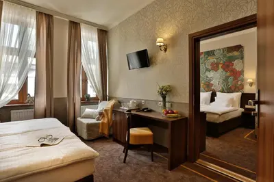 a hotel room with a desk and a bed at Amber Boutique Hotels - Amber Design in Kraków