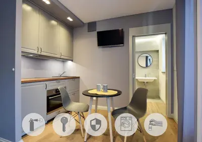 a kitchen with a table and chairs and a sink at Jewish Quarter Small Apartment in Kraków