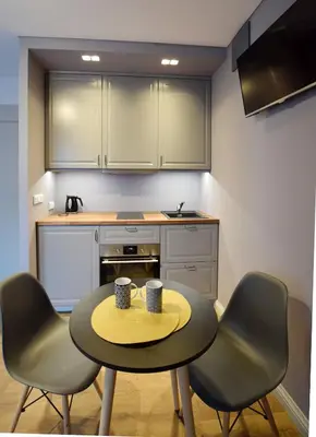 a small kitchen with a table and two chairs at Jewish Quarter Small Apartment in Kraków