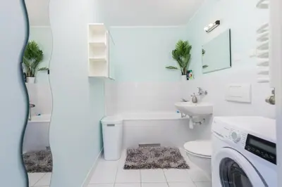 a white bathroom with a sink and a washing machine at ap4you Tauron Cracow in Kraków
