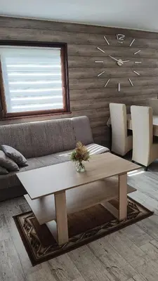 a living room with a couch and a clock on the wall at Domek Nad Brzegiem in Witanowice
