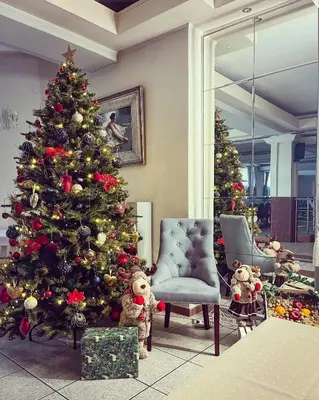 a christmas tree in a living room with two christmas trees at Hotel Victoria in Olkusz