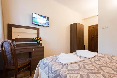 a bedroom with a bed and a dresser and a mirror at Hotel Victoria in Olkusz