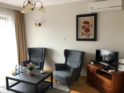 a living room with two chairs and a television at Hotel Victoria in Olkusz