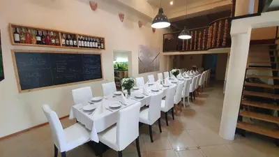 a dining room with white tables and chairs and a chalkboard at Wyspa Mszanka in Mszana Dolna