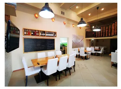 a dining room with white chairs and a wooden table at Wyspa Mszanka in Mszana Dolna