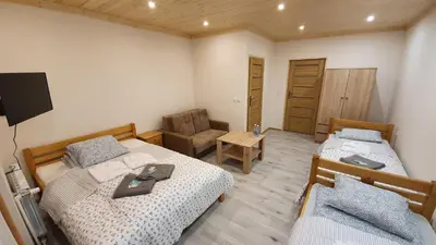 a bedroom with two beds and a chair in it at Wyspa Mszanka in Mszana Dolna