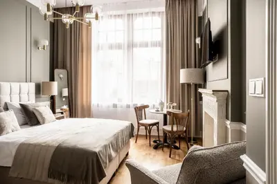 a bedroom with a bed and a table and chairs at Avanti Palazzo in Kraków