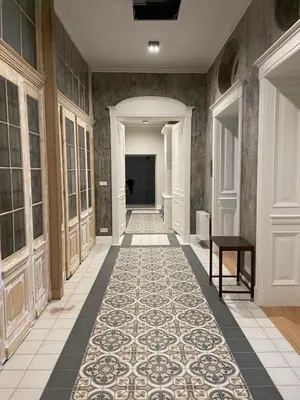 a hallway with a tile floor and a hallway with a table at Avanti Palazzo in Kraków