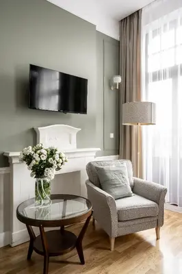 a living room with a chair and a table with a vase of flowers at Avanti Palazzo in Kraków