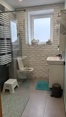 a bathroom with a toilet and a sink and a window at Domek przy Rajskiej in Jerzmanowice