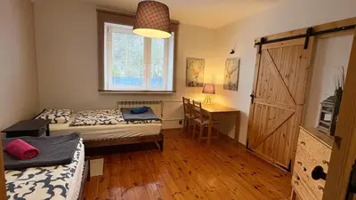 a room with two beds and a desk and a door at Domek przy Rajskiej in Jerzmanowice