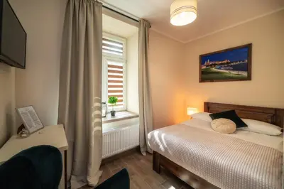 a small bedroom with a bed and a window at Apartments 17 Szewska in Kraków