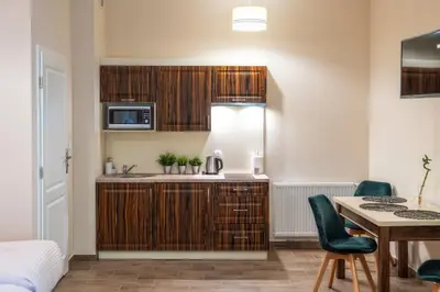 a kitchen with a sink and a table in a room at Apartments 17 Szewska in Kraków