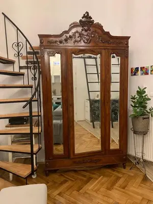a wooden cabinet with a mirror in a room at Charming studio apartment in the heart of the Jewish District! in Kraków