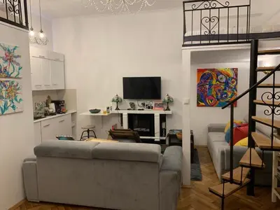 a living room with a couch and a television at Charming studio apartment in the heart of the Jewish District! in Kraków