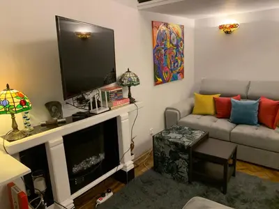 a living room with a couch and a flat screen tv at Charming studio apartment in the heart of the Jewish District! in Kraków