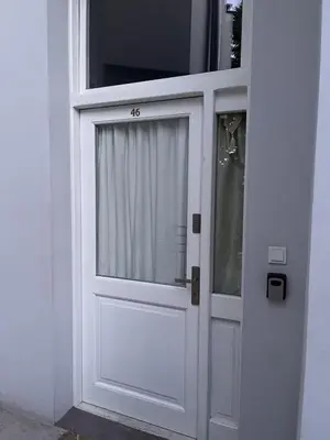 a white door with a window in a building at Charming studio apartment in the heart of the Jewish District! in Kraków