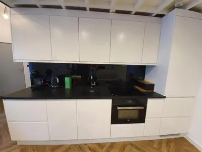 a kitchen with white cabinets and a black counter top at Old Town Apartment, Morsztynowska in Kraków