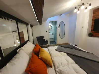 a bedroom with a bed with orange pillows and a mirror at Old Town Apartment, Morsztynowska in Kraków