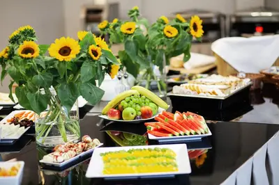 a buffet with plates of food and sunflowers at Golden Tulip Krakow City Center in Kraków