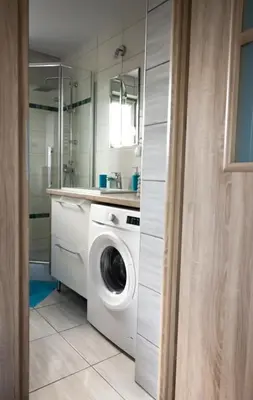 a white washer and dryer in a white kitchen at Domek POD GOLCOWEM in Limanowa
