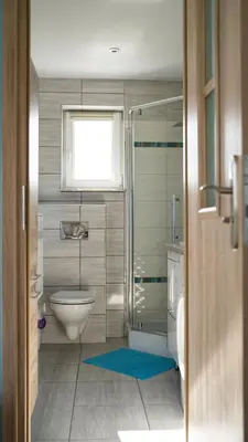 a bathroom with a shower and a toilet and a window at Domek POD GOLCOWEM in Limanowa