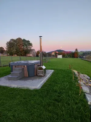 a hot tub in the middle of a grass field at Domek POD GOLCOWEM in Limanowa