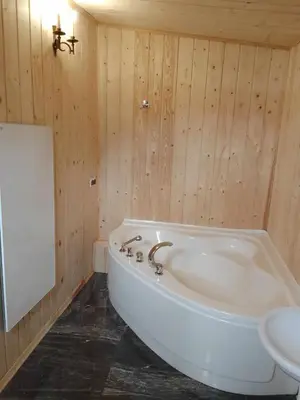 a bathroom with a tub in a wooden wall at Zajazd Ponikiew - Noclegi Wadowice in Wadowice