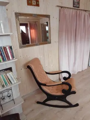a rocking chair in a room with a window at Zajazd Ponikiew - Noclegi Wadowice in Wadowice