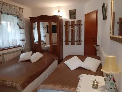 a bedroom with two beds and a table with a lamp at Zajazd Ponikiew - Noclegi Wadowice in Wadowice