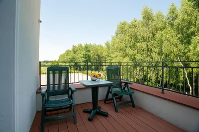 a porch with two chairs and a table on a balcony at Villa Królewiec - 1,5km od Energylandii in Zator