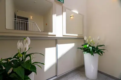 a room with a vase of flowers and a mirror at Villa Królewiec - 1,5km od Energylandii in Zator