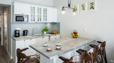 a kitchen with white cabinets and a marble counter top at MY KRAKOW Apartments - Topolowa 8 in Kraków