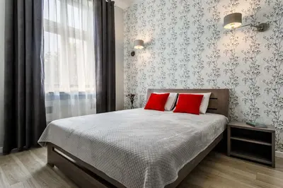 a bedroom with a bed with two red pillows at MY KRAKOW Apartments - Topolowa 8 in Kraków