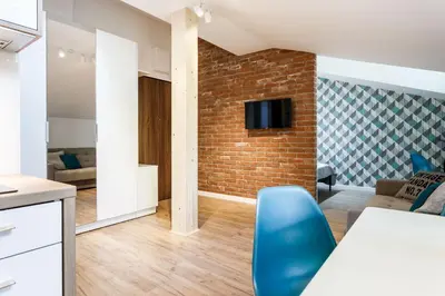 a kitchen and living room with a brick wall at MY KRAKOW Apartments - Topolowa 8 in Kraków
