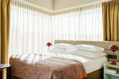 a bedroom with a bed and a large window at PURO Kraków Stare Miasto in Kraków